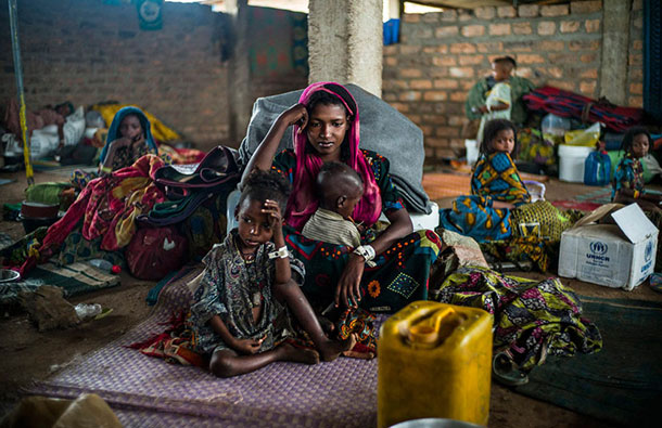 Hajara, 19, and her children await their first hot meal in over two months. They arrived at the Dosseye refugee camp in Chad the previous day after fleeing violence in Central African Republic. UNHCR/C.Fohlen