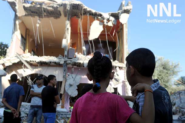 Two children stand in front of a house that police said was destroyed in an Israeli air strike in Maghazi refugee camp in Center Gaza Strip. UN Photo/Shareef Sarhan