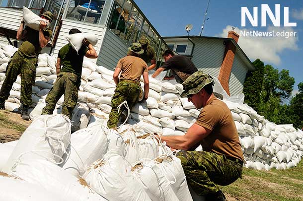 Members of 2nd Battalion, Princess Patricia's Canadian Light Infantry (2PPCLI) based out of Canadian Forces Base Shilo, Manitoba, aid locals around Portage la Prairie, Manitoba in efforts to reduce damage from flooding during Operation LENTUS on July 6, 2014. Photo: Corporal Darcy Lefebvre, Canadian Forces Combat Camera