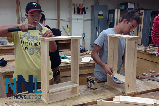 Zach Leonardi (left) and Dom Commisso work to build cabinets which they will take home today