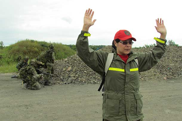 Ranger Paula Nakogee of Fort Albany keeps her hands in the air while playing the role of a prisoner of war.