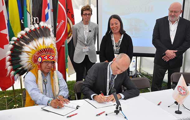 Grand Chief Harvey Yesno, Nishnawbe Aski Nation, and Michael Sherar, President and CEO of Cancer Care Ontario, signing protocol. Looking on (L-R) are Dr. Linda Rabeneck, Vice-President, Prevention and Cancer Control, Alethea Kewayosh, Director, Aboriginal Cancer Control Unit, Cancer Care Ontario, and Mark Henderson, Regional Vice-President, North West Regional Cancer Program