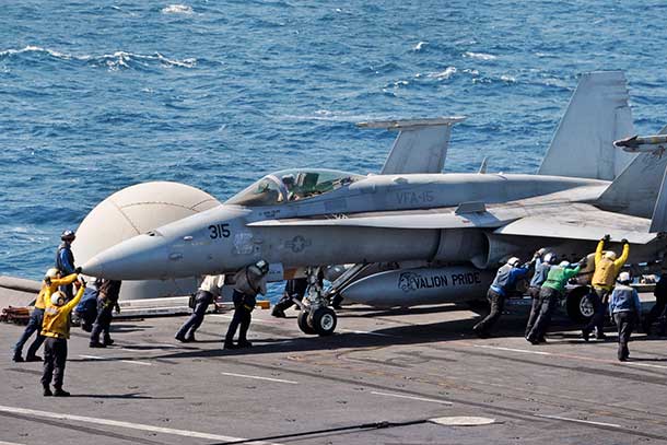 U.S. sailors guide an F/A-18C Hornet on the flight deck of the aircraft carrier USS George H.W. Bush in the Arabian Gulf, Aug. 8, 2014. The carrier is supporting maritime security operations and theater security cooperation