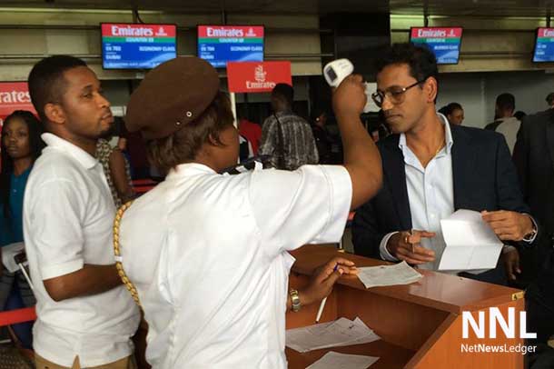 Passengers about to depart from Lagos airport, Nigeria, are being checked for their body temperature to make sure they don't have fever, one symptom of Ebola. Photo: WHO/S. Bolton