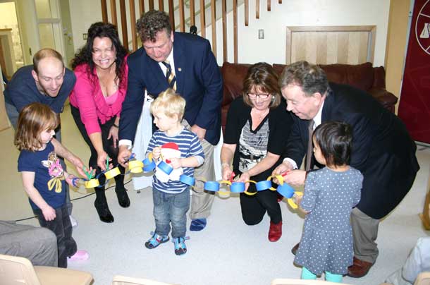 With help from some children, LUSU President Ian Kaufman; Tammy Squitti, Nanabijou Board Chair; Lakehead President and Vice-Chancellor Dr. Brian Stevenson; Norine Carroll, executive assistant to MPP Bill Mauro; and Michael Gravelle, Minister of Northern Development and Mines and Chair of the NOHFC cut a paper ribbon to celebrate the opening of the Nanabijou Childcare Centre.