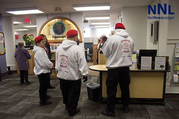 Guardian Angels getting information updates from the staff at the Brodie Street Library.