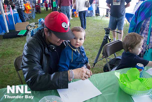 Dakota and Tai from Fort Severn try their hands at drawing with graphite at the Zenyatta Ventures exhibit.