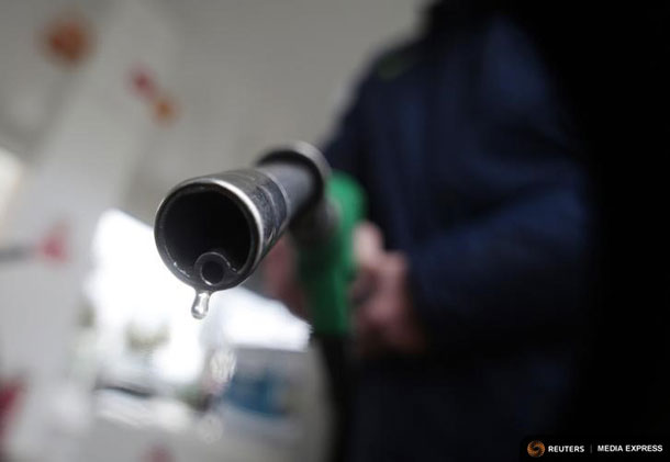 A customer holds a nozzle to fill up his tank in a gasoline station in Nice December 5, 2014. REUTERS/Eric Gaillard