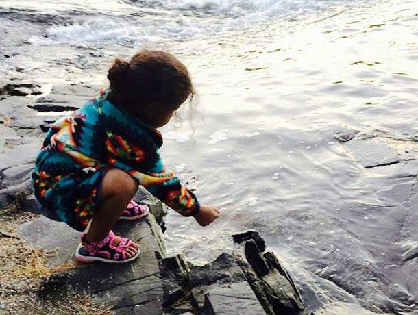 Waasayaa putting tobacco in the water in Serpent River