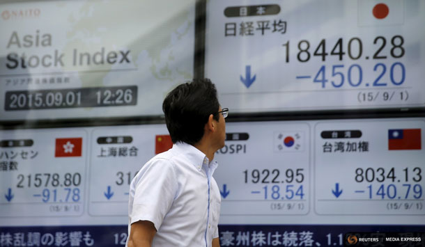 A man looks at electronic boards displaying various Asian countries' stock price indexes outside a brokerage in Tokyo, September 1, 2015. REUTERS/Toru Hanai