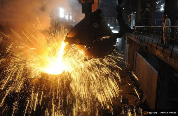 An employee monitors molten iron being poured into a container at a steel plant in Hefei, Anhui province September 9, 2013. REUTERS/Stringer