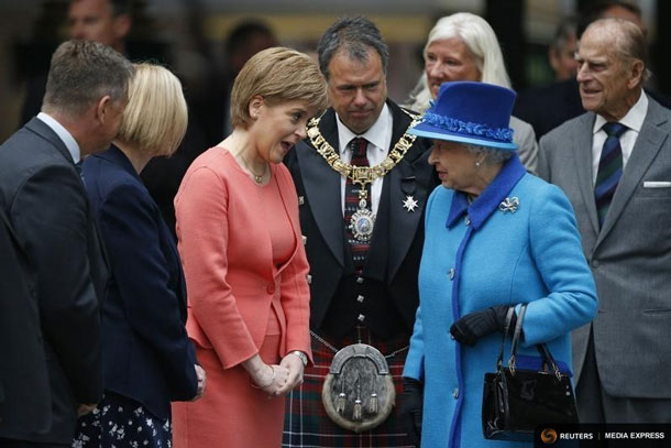 Britain's Queen Elizabeth speaks with Scotland's First Minister Nicola Sturgeon after arriving with Prince Philip (R) at Edinburgh Waverley Station, before boarding a train drawn by a steam locomotive to travel along the Scottish Borders Railway in Scotland, Britain September 9, 2015. REUTERS/Russell Cheyne