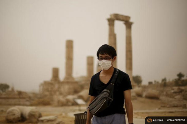 A tourist wearing a face mask walks at the Amman Citadel, during a sandstorm in downtown Amman, Jordan, September 8, 2015. A heavy sandstorm swept across parts of the Middle East on Tuesday, hospitalising scores of people in Lebanon and disrupting air strikes and fighting in neighbouring Syria. Clouds of dust also engulfed Israel, Jordan and Cyprus where aircraft were diverted to Paphos from Larnaca airport as visibility fell to 500 metres. REUTERS/Muhammad Hamed
