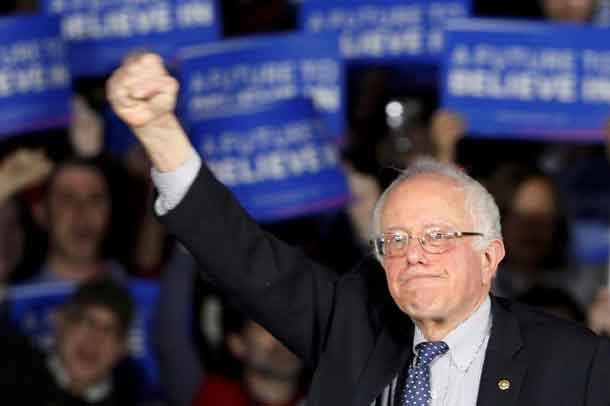 U.S. Democratic presidential candidate Bernie Sanders raises a fist as he speaks at his caucus night rally Des Moines, Iowa February 1, 2016, REUTERS/Rick Wilking