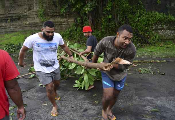 Fijian men clear a road of a fallen tree in Fiji's capital Suva after Cyclone Winston swept across Viti Levu Island, February 21, 2016. REUTERS/Taniela Qalilawa/Handout via Reuters