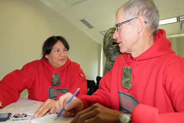 Master Corporal Linda Kamenawatamin of Bearskin Lake and Ranger Alvin Adams of Springdale, Newfoundland, work together on a navigation problem