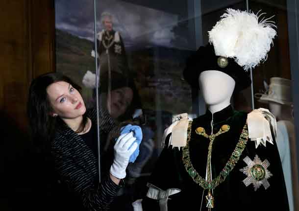 Gallery worker Caroline de Guitaut, curator at the royal collections trust, poses with part of the largest exhibition of The Queen's dresses and accessories ever shown in Scotland at the Palace of Holyroodhouse, Scotland April 20, 2016. REUTERS/Russell Cheyne