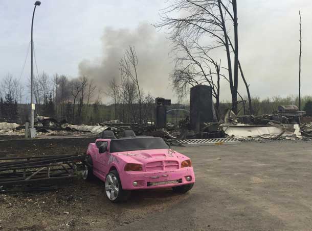 A pink car remains among the ruins of destroyed buildings after wildfires tore through the Waterways area of Fort McMurray, Alberta, Canada May 5, 2016. Courtesy of Brad Readman/Alberta Fire Fighters Association/Handout via REUTERS