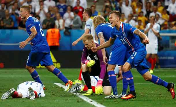 Football Soccer - England v Iceland - EURO 2016 - Round of 16 - Stade de Nice, Nice, France - 27/6/16 Iceland players celebrate as England's Joe Hart looks dejected after the game REUTERS/Kai Pfaffenbach Livepic