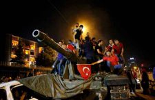 People stand on a Turkish army tank in Ankara