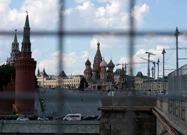 A view through a construction fence shows the Kremlin towers and St. Basil's Cathedral on a hot summer day in central Moscow, Russia, July 1, 2016. REUTERS/Maxim Zmeyev/File Photo