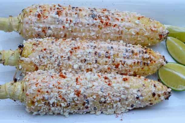 Mexican Street Corn With a Global Twist. Bring Mexico’s favorite street food home. Mix plain Greek yogurt with 2 teaspoons Sriracha Hot Chili Sauce. Grill husked corn on high heat with the lid down, turning occasionally until lightly charred on all sides (10 to 15 minutes). Generously brush each ear with yogurt mixture. Sprinkle with Cotija cheese (or ricotta salata) and chili powder to taste. Squeeze a lime wedge over each ear before serving. Credit: Copyright 2016 Tina Caputo