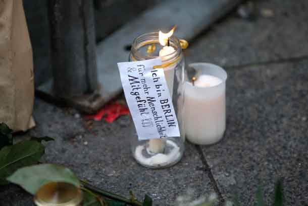 A candle with a sticker reading "I am Berlin - For more humanity and compassion" near the scene where a truck ploughed into a crowded Christmas market in the German capital last night in Berlin, Germany, December 20, 2016.. REUTERS/Fabrizio Bensch