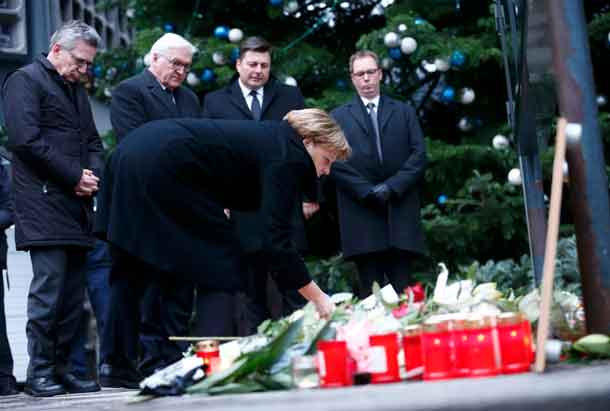 German Chancellor Angela Merkel lays flowers at the Christmas market in Berlin, Germany, December 20, 2016, one day after a truck ploughed into a crowded Christmas market in the German capital.       REUTERS/Hannibal Hanschke