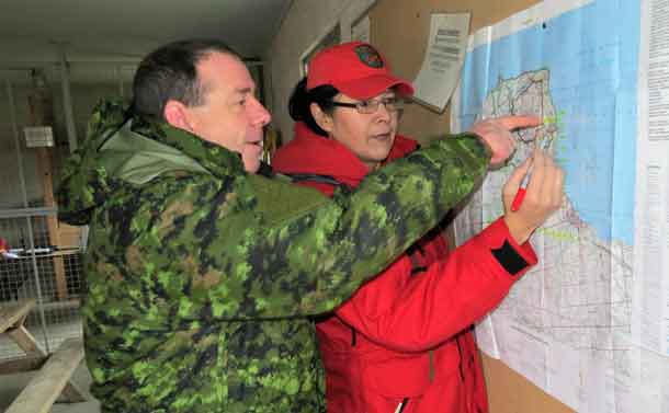Warrant Officer Barry Borton, a 3 CRPG instructor, shows Corporal Paula Nakagee of Fort Albany how to use a map during a training exercise.
