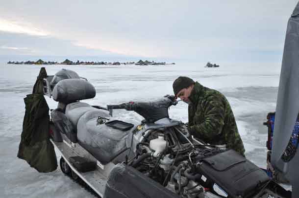 Thunder Bay Reservist Private Logan Dupuis of 38 Service Battalion works on repairing a snowmobile on Lake Winnipeg during Exercise ARCTIC BISON 2017. The exercise is 38 Canadian Brigade Group’s Arctic Response Company Group’s (ARCG) annual training opportunity that allows soldiers to train their non-tactical winter warfare skills. Photo Credit Cpl Natasha Tersigni, 28 CBG Public Affairs 