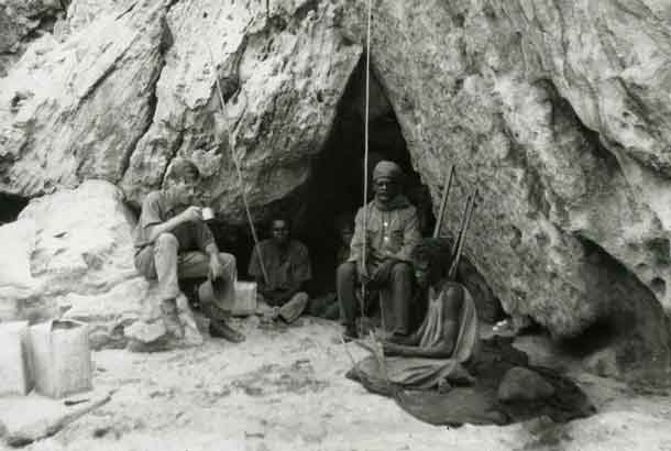 Rockshelter at Bathurst Head (Thartali) in eastern Cape York Peninsula, occupied by the expedition during field work. Pictured: Norman Tindale and local Aboriginal group. CREDIT Photo by Herbert Hale. February 1927. South Australian Museum Archives Norman Tindale Collection (AA 338/5/4/41)