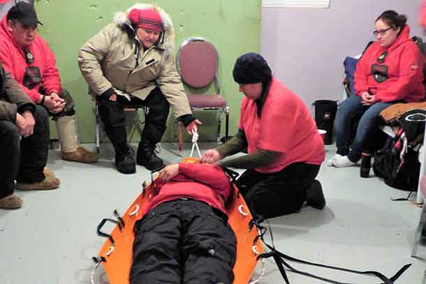 Sergeant Mary Miles shows Canadian Rangers how to use a new type of stretcher.