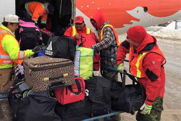 Canadian Rangers load evacuees' baggage onto plane.