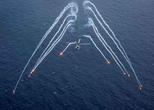 A U.S. Navy MH-60R Sea Hawk helicopter from the "Blue Hawks" of Helicopter Maritime Strike Squadron 78 fires chaff flares during a training exercise near the aircraft carrier USS Carl Vinson (CVN 70) in the Philippine Sea.  U.S. Navy/Mass Communication Specialist 2nd Class Sean M. Castellano/via REUTERS