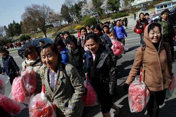 Women carry accessories and plastic flowers as North Korea prepares to mark Saturday's 105th anniversary of the birth of Kim Il-sung, North Korea's founding father and grandfather of the current ruler, in central Pyongyang, North Korea April 12, 2017. REUTERS/Damir Sagolj