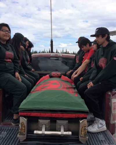 Junior Canadian Rangers, several crying, flank the casket as it is driven from the airport to the church.