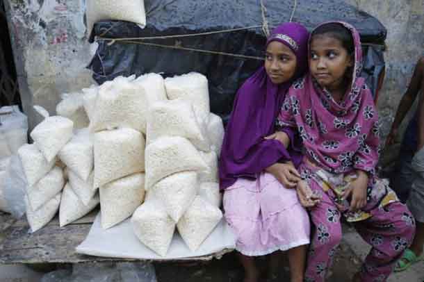 Muslim girls sell puffed rice at a roadside shop during the holy fasting month of Ramadan, in Dhaka July 8, 2014. REUTERS/Andrew Biraj