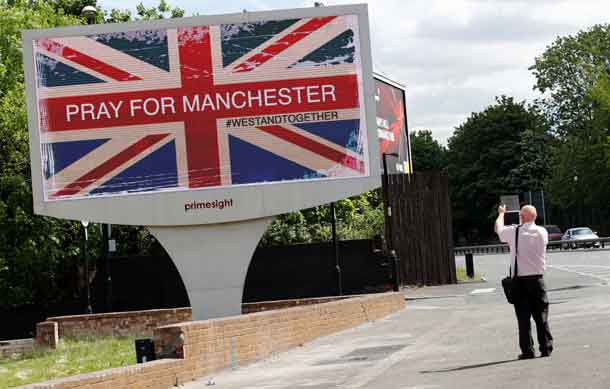 A man photographs a sign in Manchester, Britain May 23, 2017. REUTERS/Stefan Wermuth