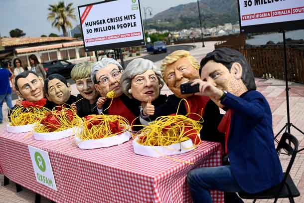 Protestors wearing masks depicting the leaders of the G7 countries pose for a selfie during a demonstration organised by Oxfam in Giardini Naxos, Sicily, Italy May 25, 2017. REUTERS/Dylan Martinez