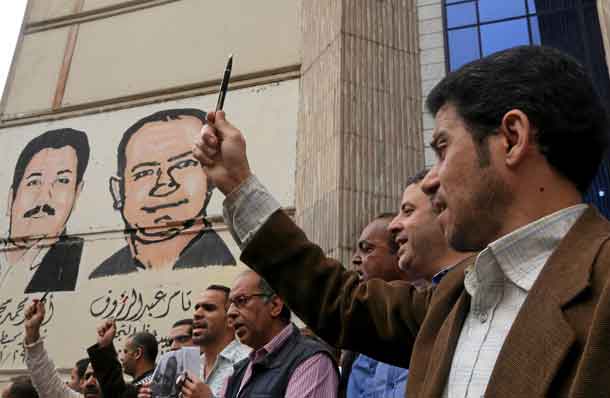FILE PHOTO: A journalist holds up a pen during a protest against the detention of journalists, in front of the Press Syndicate in Cairo, Egypt April 26, 2016. REUTERS/Mohamed Abd El Ghany/File Photo