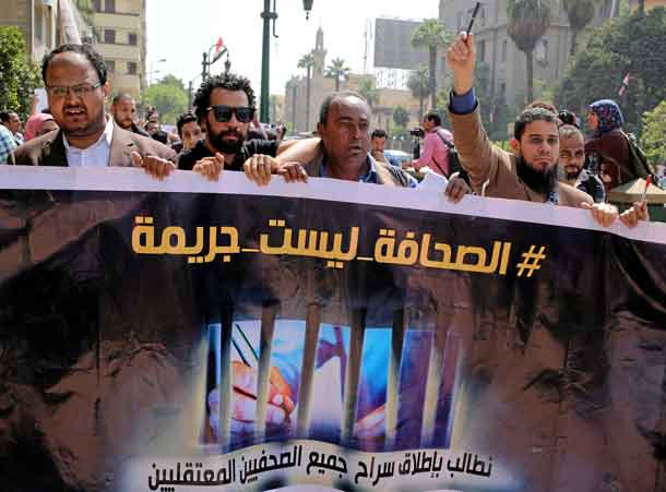 FILE PHOTO: Egyptian journalists hold a banner outside the Egyptian Press Syndicate in downtown Cairo, Egypt April 28, 2016. The banner reads 