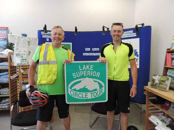 Greg Massey, 60, of Blaine, Minnesota, and son David, 29, of Minneapolis, biked around Lake Superior this summer to celebrate Greg’s retirement. They began and ended the Circle Tour in Duluth, where they marked the accomplishment with a photo at the Lake Superior Circle Tour Headquarters, part of Lake Superior Magazine’s offices at 310 E. Superior St. (Konnie LeMay / Lake Superior Magazine)