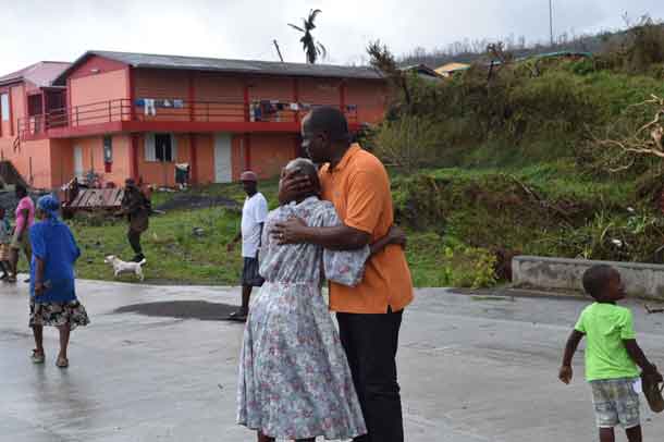 Barbuda has been hammered hard by hurricane winds. The Prime Minister seeks to console this woman.