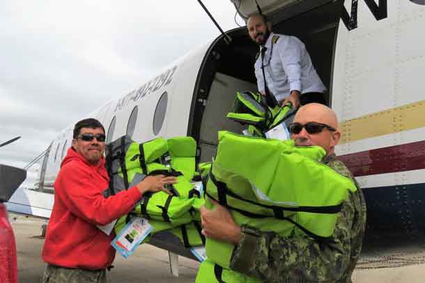 Ranger Redfern Wesley and Warrant Officer Carl Wolfe unload life jackets at Kashechewan airport.