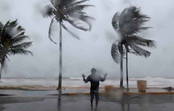 A man reacts in the winds and rain as Hurricane Irma slammed across islands in the northern Caribbean on Wednesday, in Luquillo, Puerto Rico September 6, 2017. REUTERS/Alvin Baez
