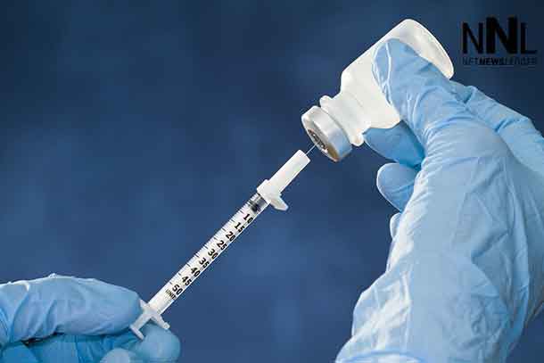 Medical worker wearing protective gloves prepares to administer a flu shot.