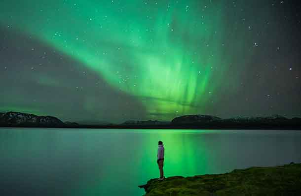 Man with Northern Lights reflection