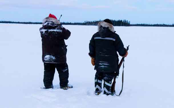 Sergeant Matthew Gull, left, and Corporal Maurice Mack check a lake for signs of the missing trapper. Photo by Jason Hunter