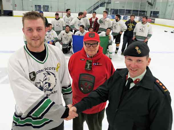 Master Corporal Adam Phelps of the Lorne Scots is congratulated on his team's win at hockey tournament supporting the Canadian Rangers by Colonel Dan Stepaniuk, right. John Newman, honorary lieutenant-colonel of the Rangers in Northern Ontario, is at centre. Credit Sergeant Peter Moon, Canadian Rangers