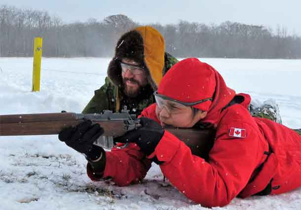 Ranger Jocelyn Yellowhead of Neskantaga shoots under the watchful eye of Sergeant Ben Kirke, an army instructor.